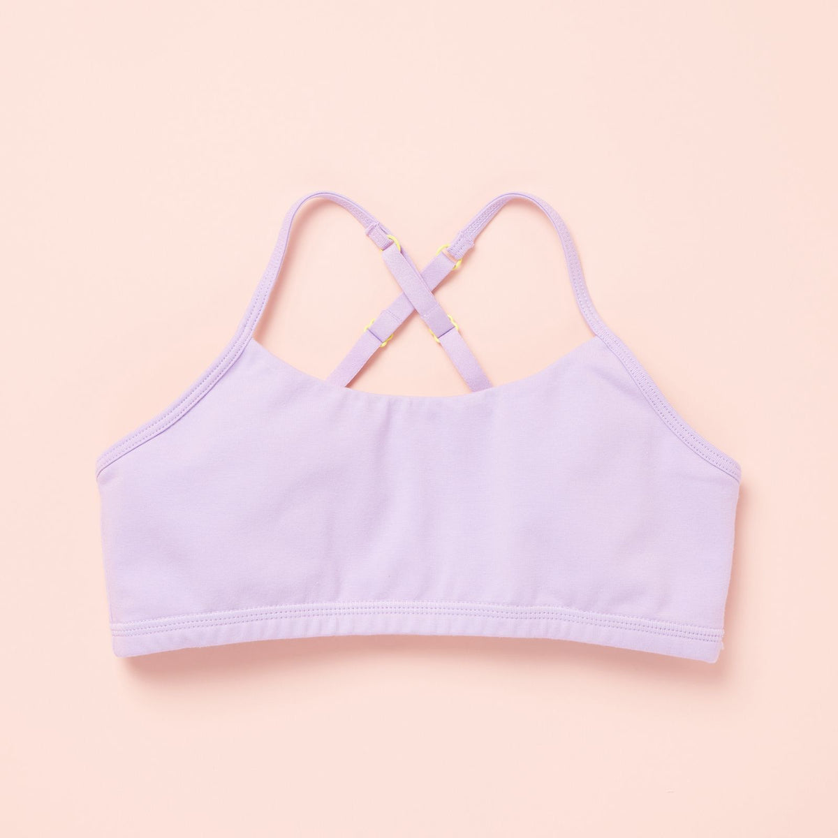 Lavender bralette with thin straps on a light pink background