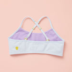 Light purple and lavender sports bra with thin straps on a pink background