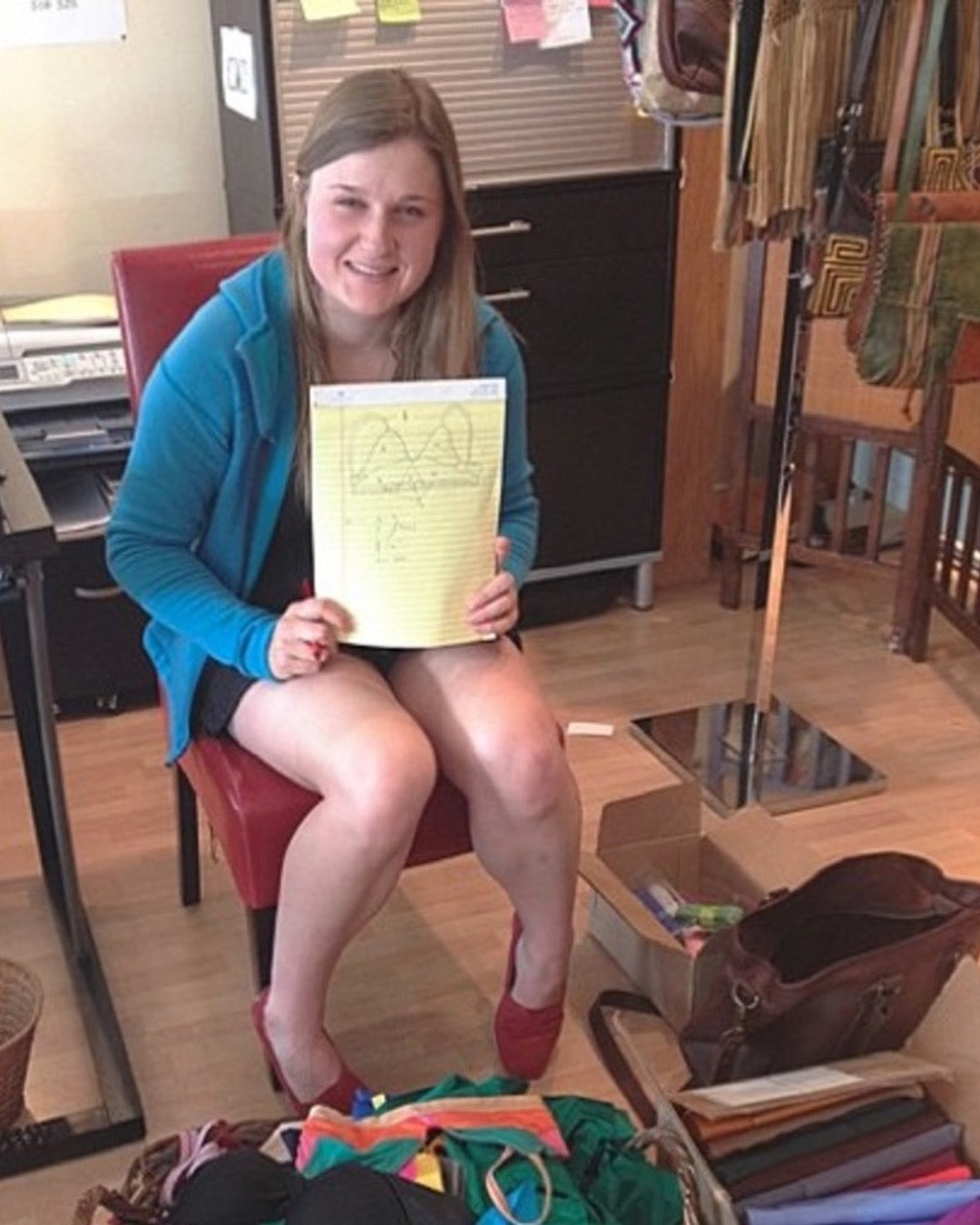 Person sitting on a chair holding a piece of paper in an indoor setting