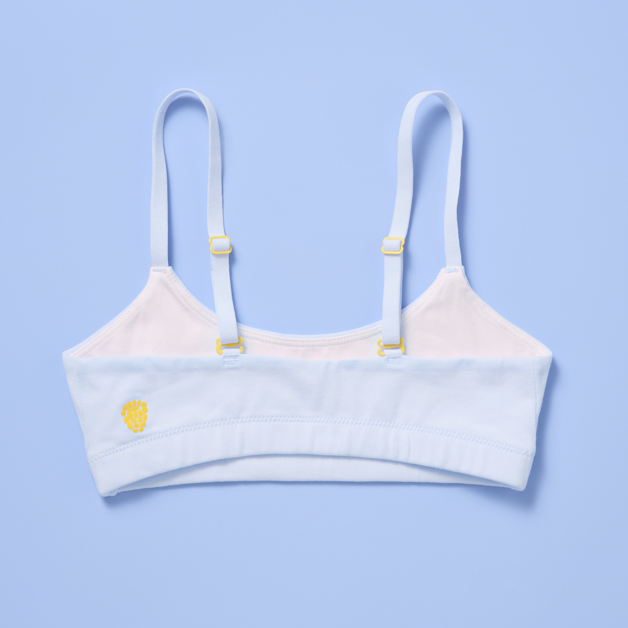 Yellowberry Pipit Raindrop training bra, back laydown with yellow logo and sliders, light blue on a blue background