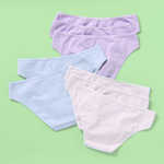 Eight pairs of women's bikini-style underwear in pastel shades of lavender, light blue, and white, arranged in a fan-like flat lay on a solid light green background.
