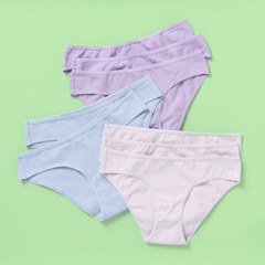 Eight pairs of women's high-waisted briefs in pastel shades of lavender, light blue, and off-white, arranged in a stacked fan layout on a solid light green background.