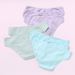 Eight pairs of women's bikini-style underwear in pastel colors, arranged in a flat-lay on a light pink background. The front pair is light aqua blue, the middle pair is mint green, and the back pair is light lavender purple.