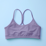 A lavender purple sports bra with a crossover back strap design, laid flat on a light blue background.