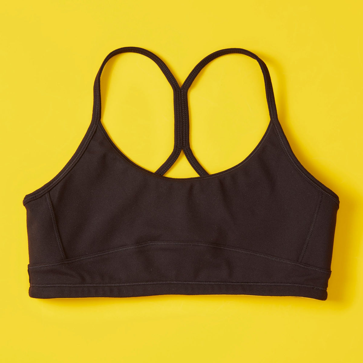 Black sports bra on a yellow background