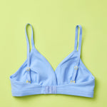 Yellowberry Butter Bra in ocean (a light blue), back laydown detail image. The BEST Bra We Make for More Developed Girls. Fabric is smooth to the touch and made with a matte brushed finish for extra softness. Made with synthetic fabric blend and hook and eye clasp closure. Great for developing girls. Wear and wash is over and over again, it will still look brand new. It will grow with your daughter as she continues to grow, great option for any occasion.