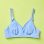 Yellowberry Butter Bra in ocean (a light blue), front laydown detail image. The BEST Bra We Make for More Developed Girls. Fabric is smooth to the touch and made with a matte brushed finish for extra softness. Made with synthetic fabric blend and hook and eye clasp closure. Great for developing girls. Wear and wash is over and over again, it will still look brand new. It will grow with your daughter as she continues to grow, great option for any occasion.