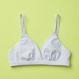 Yellowberry Butter Bra in storm (a light grey), front laydown detail image. The BEST Bra We Make for More Developed Girls. Fabric is smooth to the touch and made with a matte brushed finish for extra softness. Made with synthetic fabric blend and hook and eye clasp closure. Great for developing girls. Wear and wash is over and over again, it will still look brand new. It will grow with your daughter as she continues to grow, great option for any occasion.