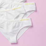 Best-Selling Twistr Girls Seamless Bikini cut underwear by Yellowberry. Front detail image of snowflake (white) bundle on pink background. 
