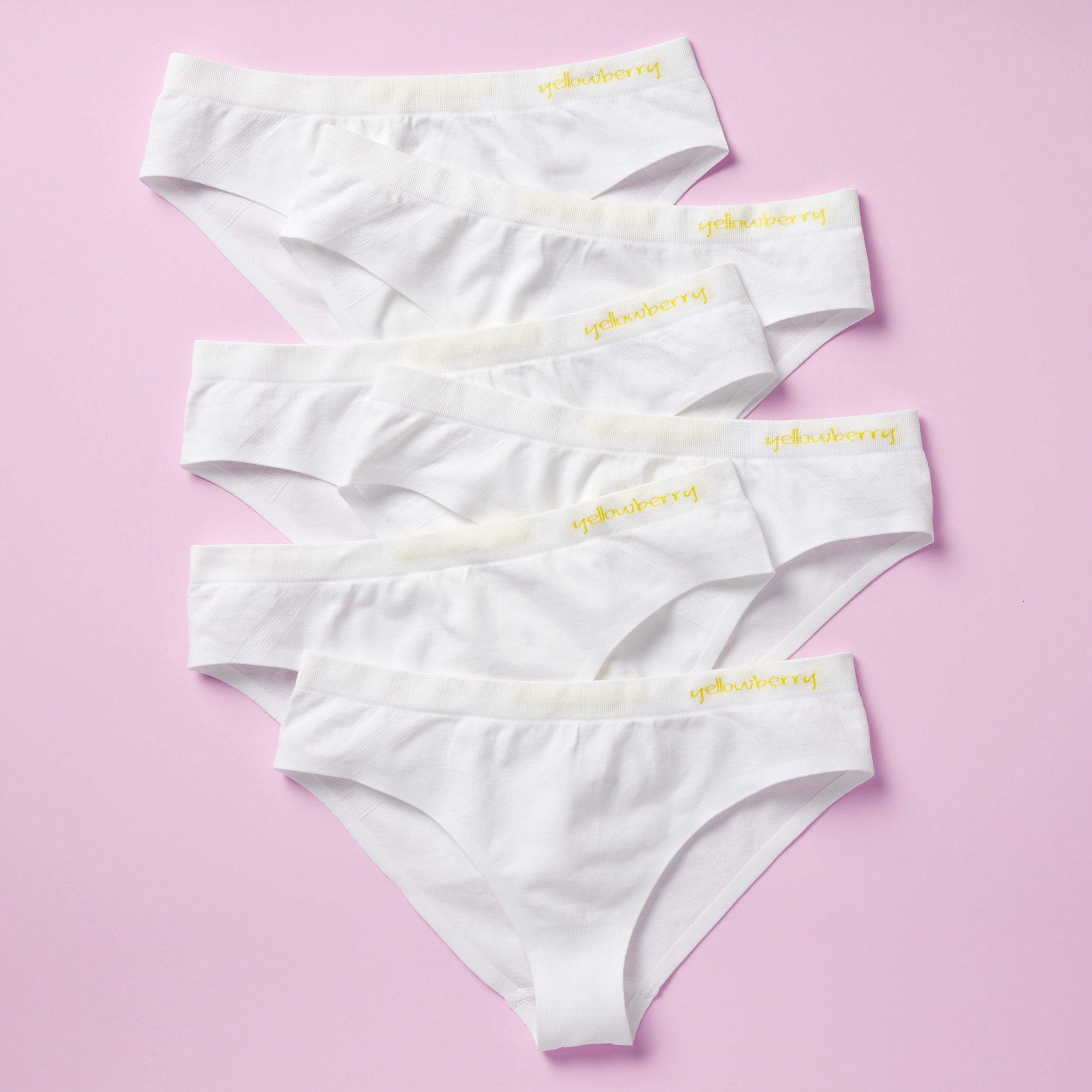 Best-Selling Twistr Girls Seamless Bikini cut underwear by Yellowberry. Front image of Snowflake (white) bundle on pink background. 