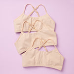 Beautiful Pima Cotton Ladybug Starter Bras in the Doe Color 3PK Bundle. Three beige bras with lavender lining, all made of super soft Pima Cotton, and photographed on a pink background front lay-down image