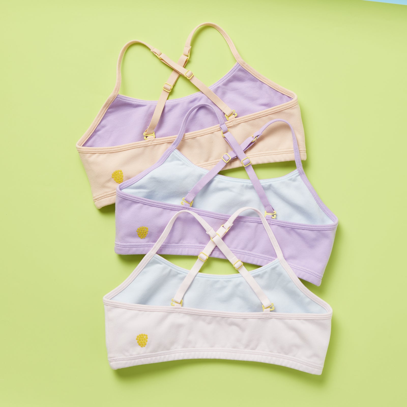 Beautiful Pima Cotton Ladybug Bras in the Summer Color 3PK Bundle. One beige bra with lavender lining, one lavender bra with light blue lining and one white bra with light blue lining all made from Pima Cotton and photographed on a lime green background.