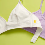 A beautiful Yellowberry Lily bra close up in Bubblegum with a Yellowberry Ladybug in Huckleberry against a lime green background.