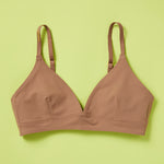 Yellowberry classic Lily bra has plenty of room for growth, stretch, and change. Its clean, simple design gives a little more definition and classic support than some of our other bras, with adjustable straps for the best fit. Lilly Bra front in Mocha against a lime background.
