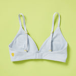 Yellowberry classic Lily bra in Raindrop Light Blue has plenty of room for growth, stretch, and change. Its clean, simple design gives a little more definition and classic support than some of our other bras, with adjustable straps for the best fit. Lilly Bra back in Raindrop against lime yellow green background showing adjustable straps and band.