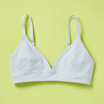Yellowberry classic Lily bra in Raindrop Light Blue has plenty of room for growth, stretch, and change. Its clean, simple design gives a little more definition and classic support than some of our other bras, with adjustable straps for the best fit. Lilly Bra front in Raindrop against lime yellow green background.