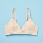 The Yellowberry Lily bra has plenty of room for growth, stretch, and change. Its chic design gives a little more definition and classic support than some of our other bras, with adjustable straps for the best fit. Lilly Bra front Doe Beige on light blue background.
