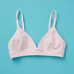 Yellowberry ever popular Lily bra in customer favorite Bubblegum pale pink has plenty of room for growth, stretch, and change. Its clean, simple design gives a little more definition and classic support than some of our other bras, with adjustable straps for the best fit. Lilly Bra Bubblegum front image against turquoise background.