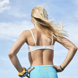 Designed with more developed girls in mind, the Yellowberry Lily bra has plenty of room for growth, stretch, and change. Its chic design gives a little more definition and classic support than some of our other bras, and the back hook and eye clasp offers easy adjustments for the best fit. On model against blue sky an with scrunchies and Yellowberry Legging.