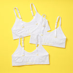 Yellowberry Seamless Bras for everyday, all all-day wear. A great bra for these girls. Super soft, easy, comfortable support and a super quality product. The PK Bundle of white Tulip Bras on a yellow background.