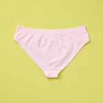 Yellowberry Twistr Seamless Underwear in Bloom (subtle light pink color) on a green background, back image. These underwear are true seamless, high quality girls underwear and made with super soft fabrics. Girl and mom approved!