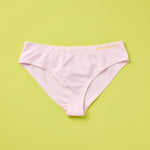 Yellowberry Twistr Seamless Underwear in Bloom (subtle light pink color) on a green background. These underwear are true seamless, high quality girls underwear and made with super soft fabrics. Girl and mom approved!