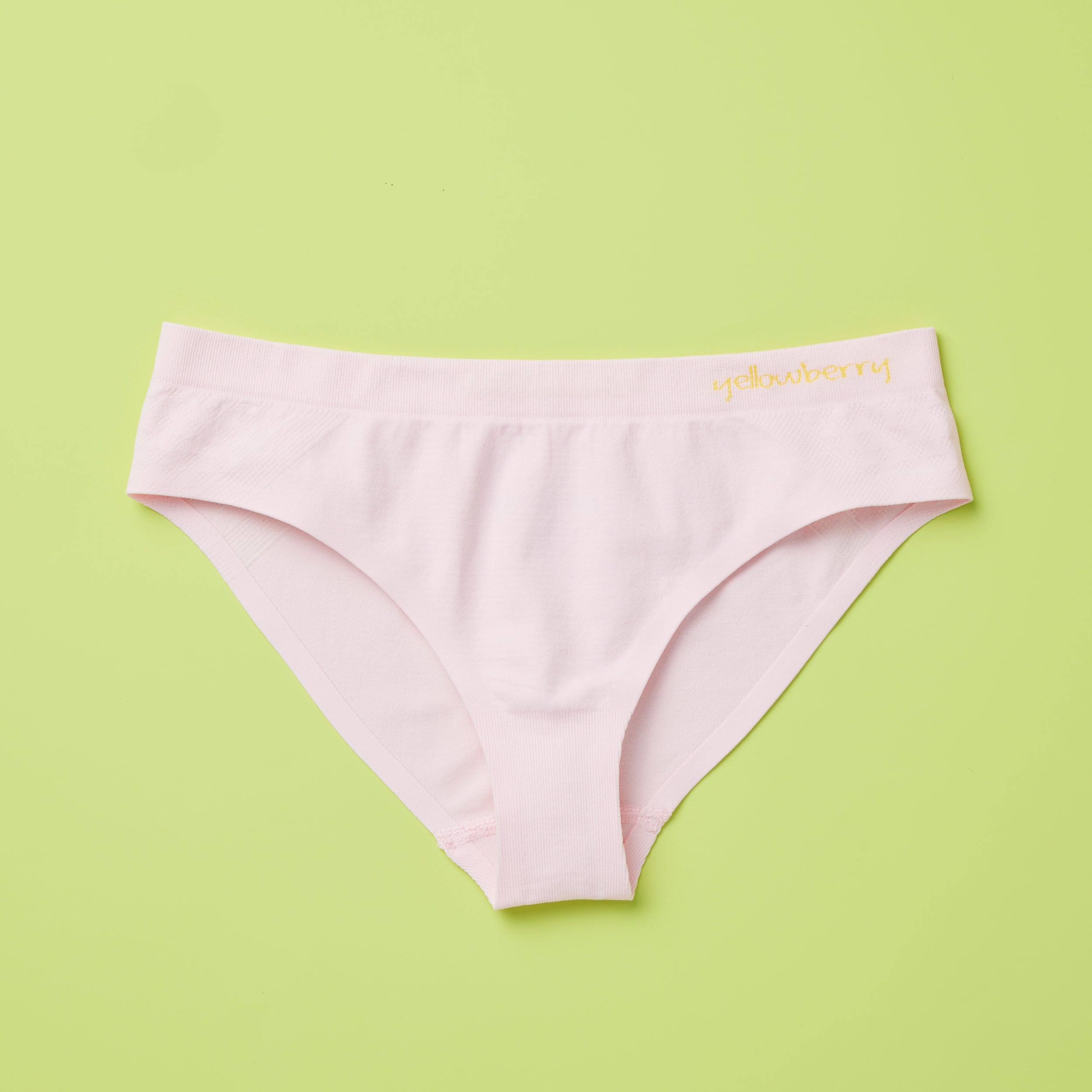 Yellowberry Twistr Seamless Underwear in Bubblegum (light pink color) on a green background. These underwear are true seamless, high quality girls underwear and made with super soft fabrics. Girl and mom approved!