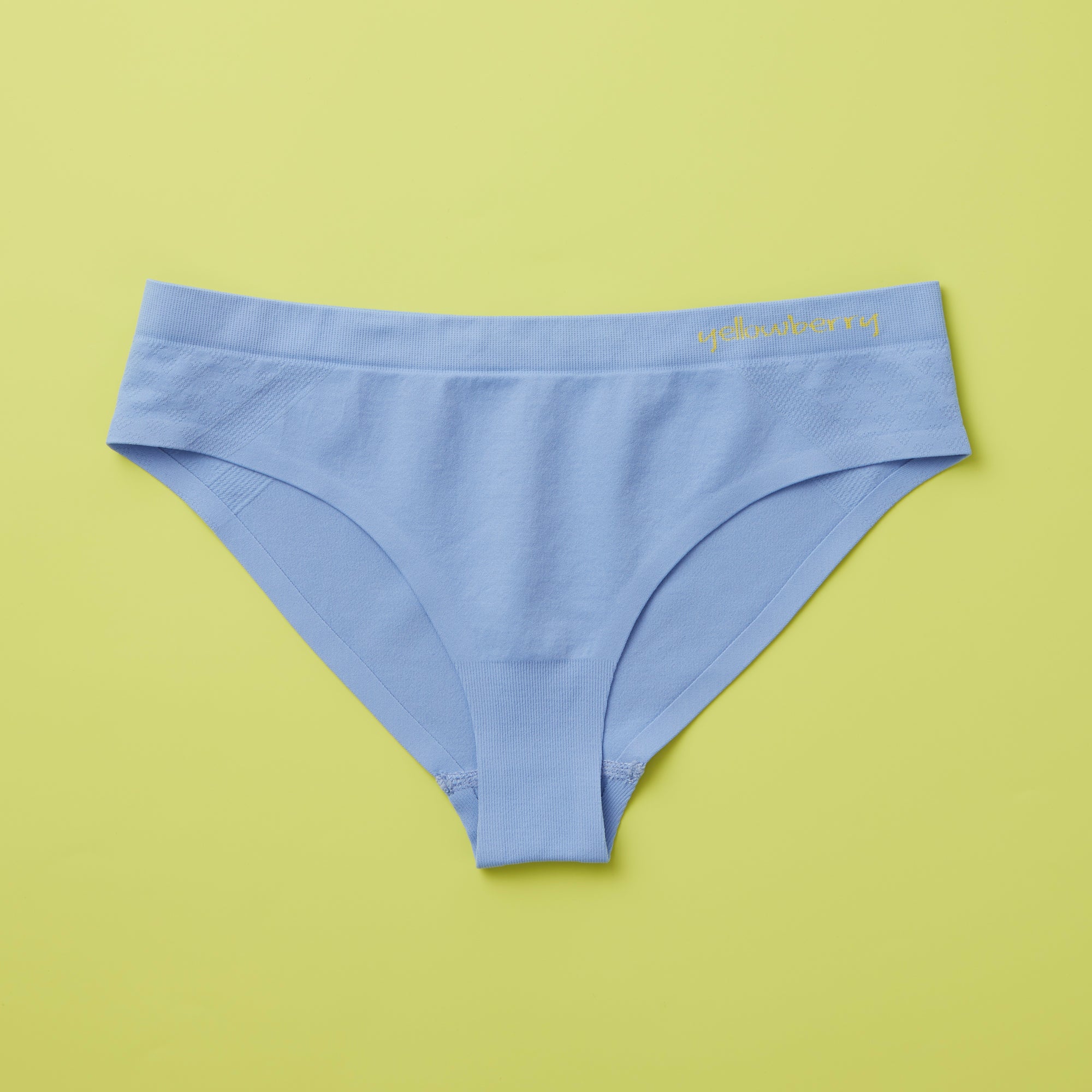 Yellowberry Twistr Seamless Underwear in Ocean (blue color) on a green background. These underwear are true seamless, high quality girls underwear and made with super soft fabrics. Girl and mom approved!