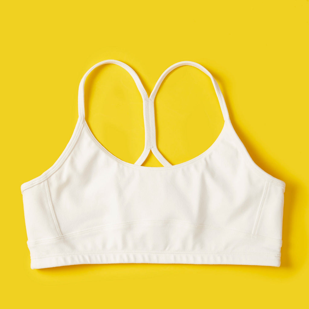 Front detail image of Yellowberry Tink Hybrid Sports Bra in white. Like two bras in one. Made with high quality, double-layered, antimicrobial, moisture wicking fabric. Made for all high impact and light activity. High to medium support for girls.
