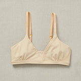 Front close detail image of Yellowberry Wish Bra in beige. The Wish Bra gives supportive definition through shearing and soft space for girls to grow. This means there is room for development without cups, padding, or underwires. The Wish Bra is double-layered and fully lined to ensure full coverage.