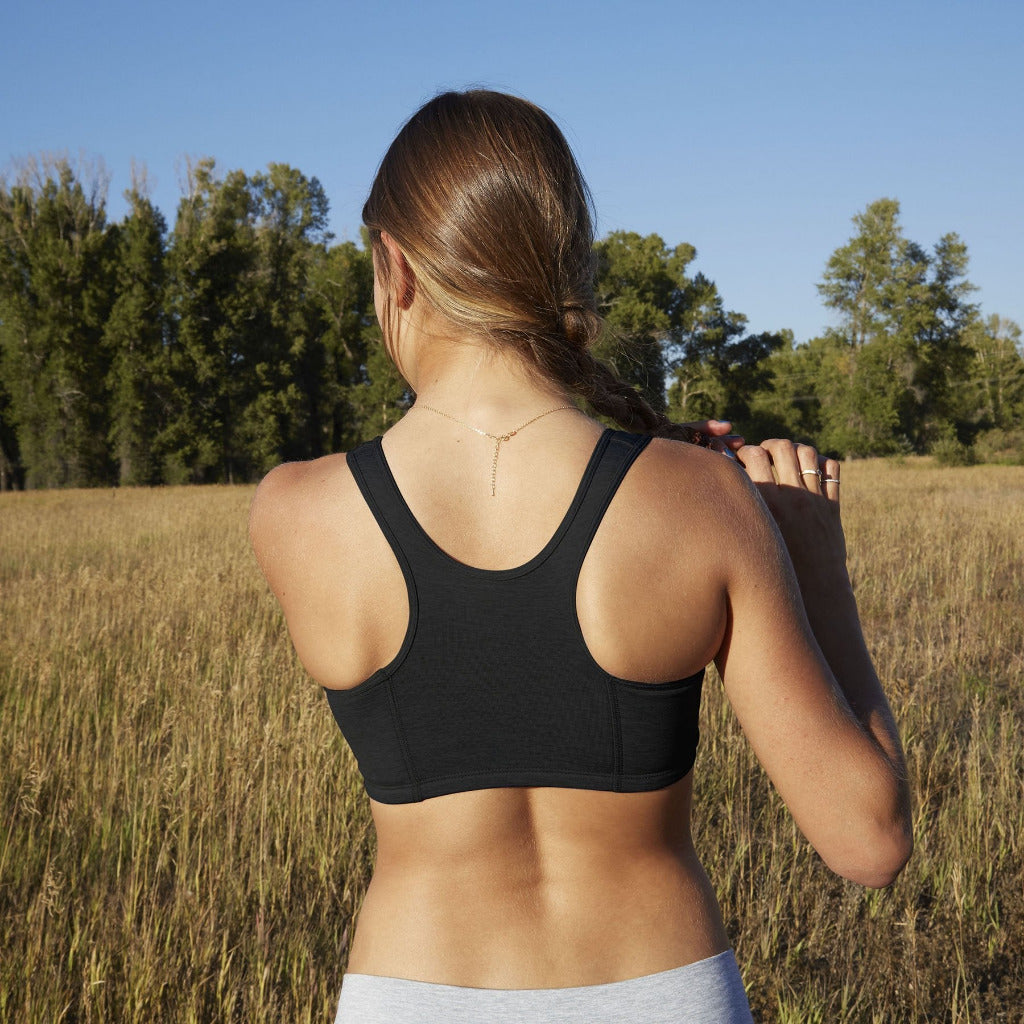 Girl wearing Half Moon Bra in black. The Yellowberry’s original sports bra. Newly redesigned and improved high-impact style. All natural fabrics. sweat-wicking, antimicrobial. Featuring a wider width racerback and buttery soft fabric. Great for sensitive skin.