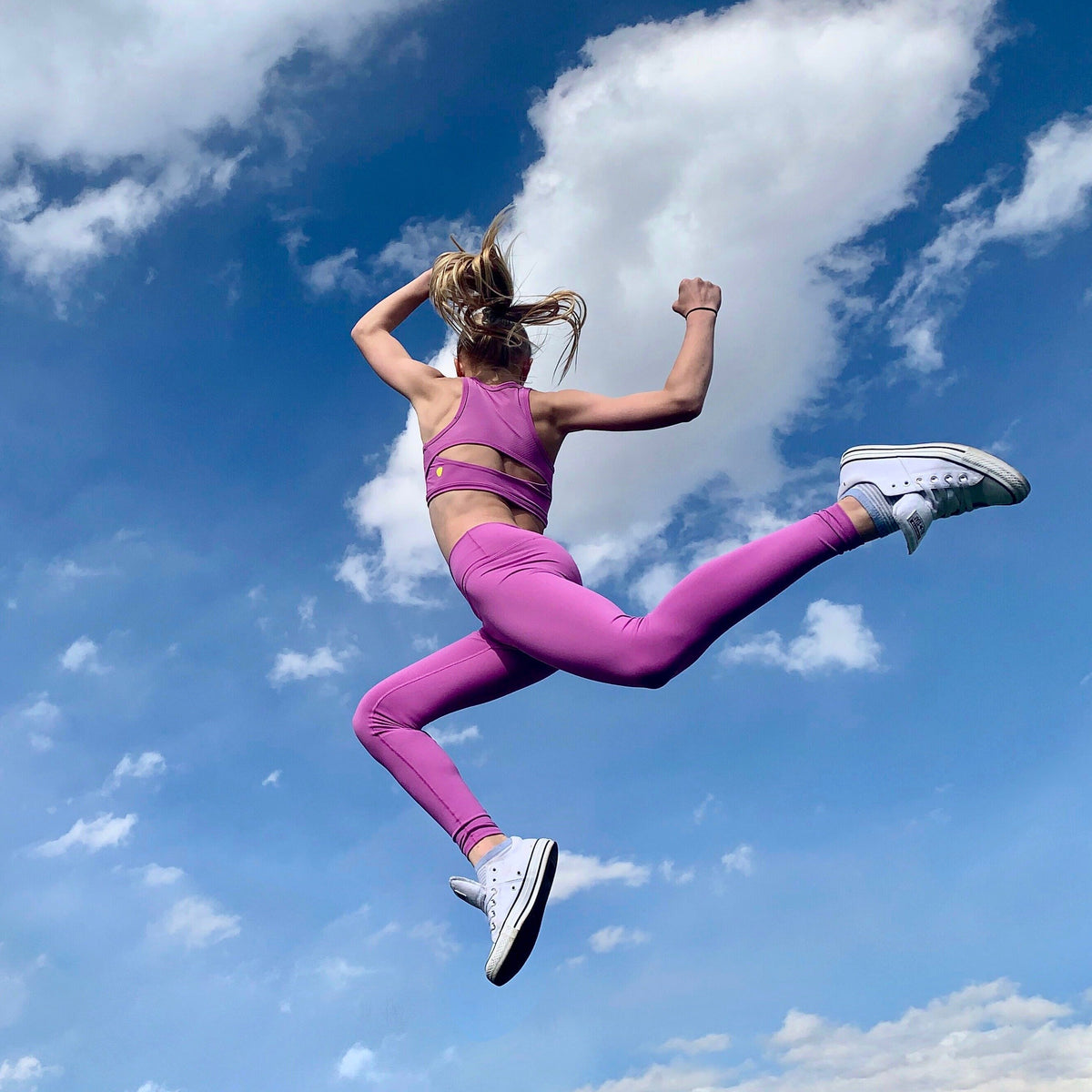 Girl jumping while wearing NEW Hula Crop Bra in Purple Clementine (Purple Pink)