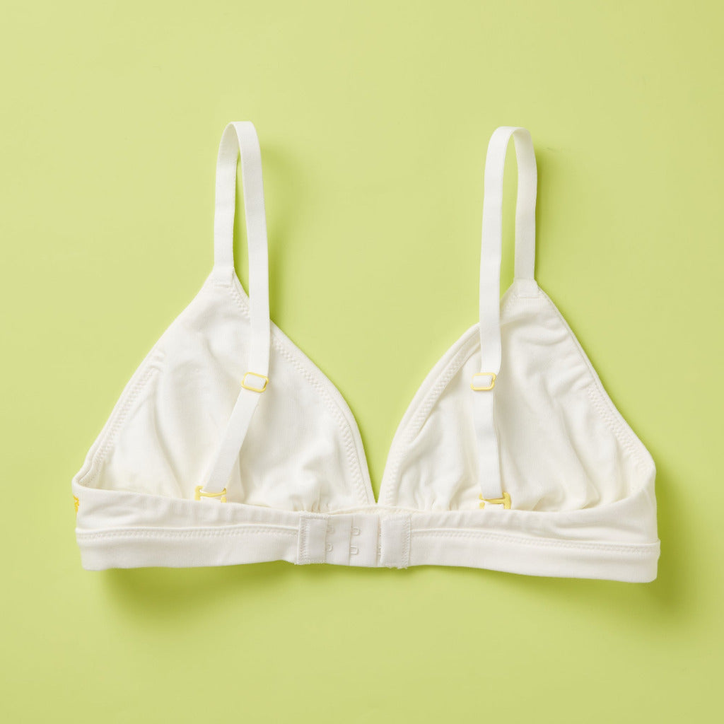 Yellowberry’s Joey Bra for Girls: A bra that grows with you. Made with double layered cotton-spandex fabric (great for sensitive skin!) just for girls beginning to develop. For girls, by girls! Back laydown white.