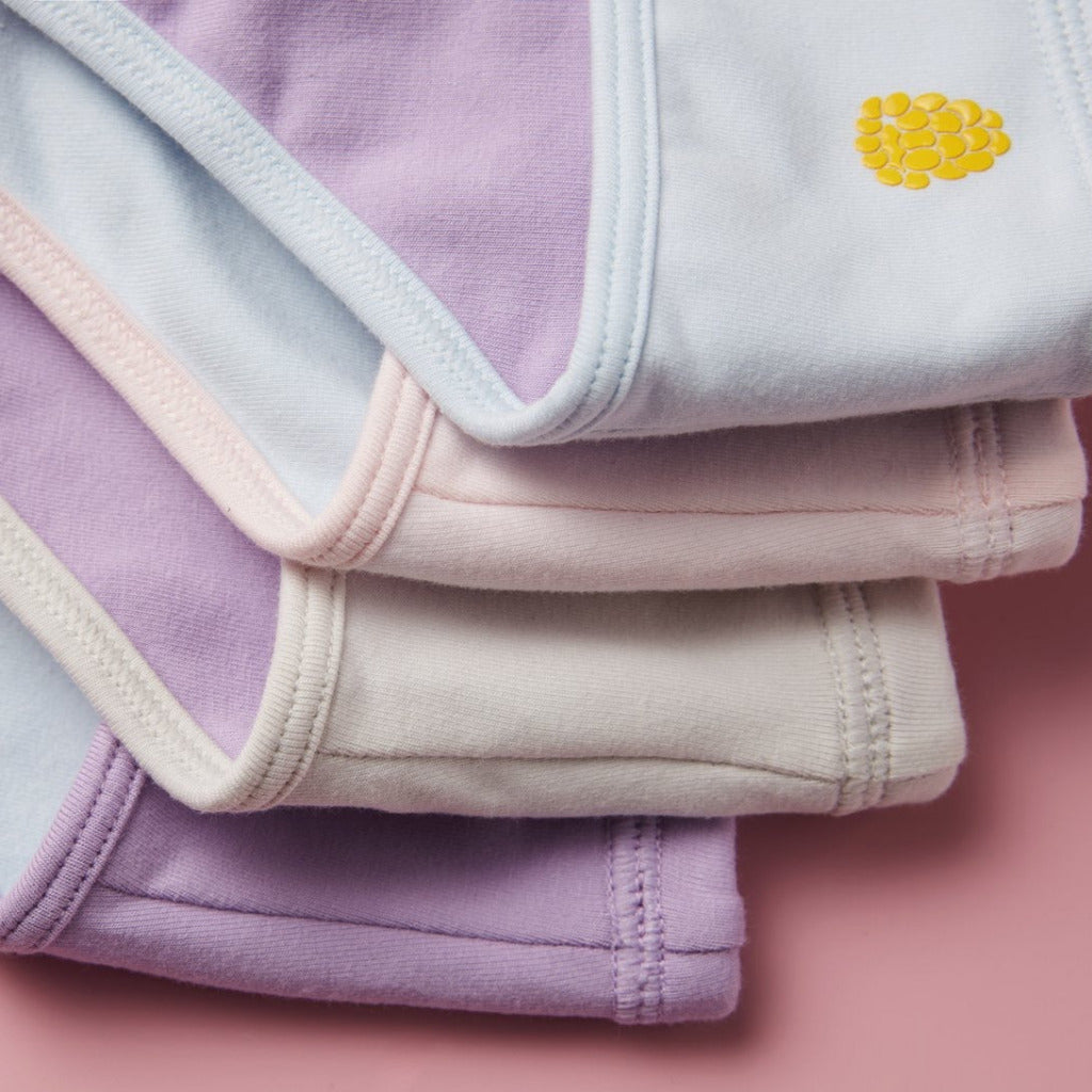 Up close detail photo of four Yellowberry Ladybug First Bras. Soft cotton fabric, moiseture wicking, antimicrobial and made for all girls, tweens, and teens in need of training bras.